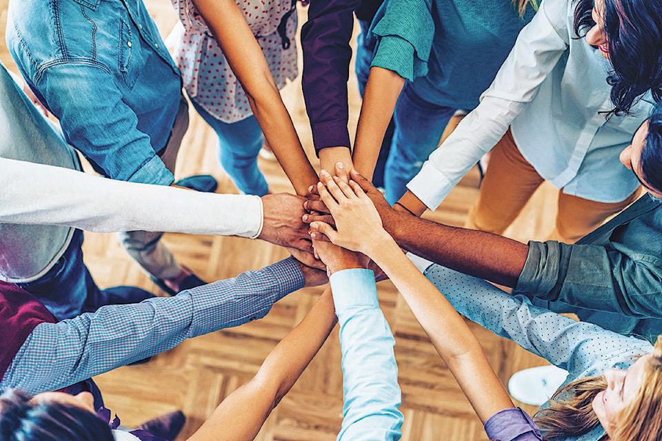 People form a circle, reach inward, and pile their hands in the center.